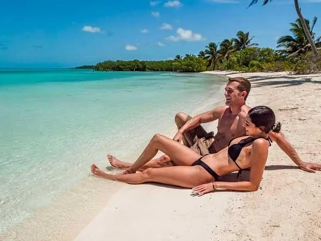 Una pareja relajándose en la playa de arena blanca de Isla Contoy